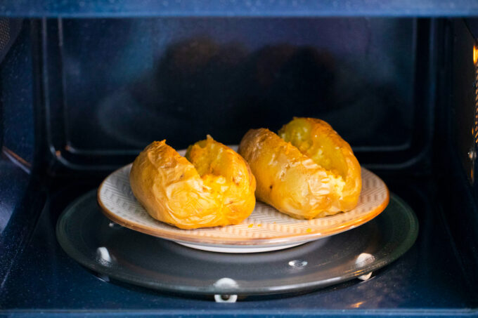 Microwaving two potatoes.
