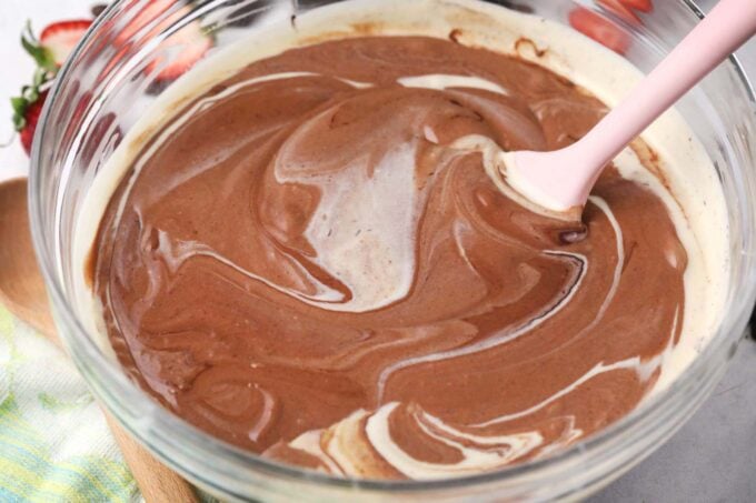 Mixing melted Godiva chocolate into cheesecake batter.