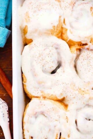 close shot of carrot cake cinnamon rolls topped with cinnamon cream cheese frosting
