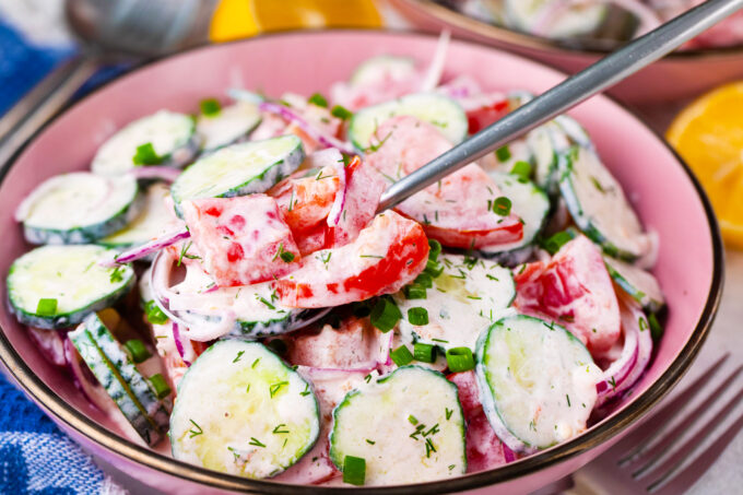 A bowl of creamy cucumber tomato salad.