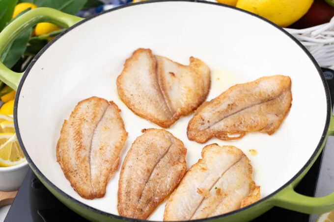 Cooking swai fish fillets in a skillet.