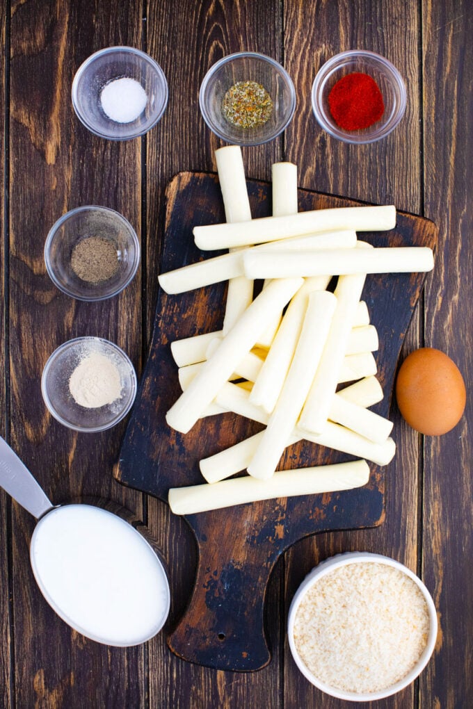 Crispy fried cheese sticks ingredients arranged on a wooden surface.