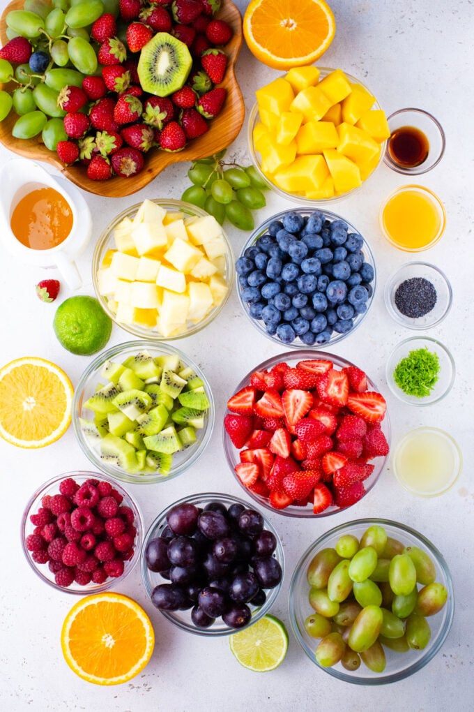 Overhead shot of fruit salad ingredients in bowls.
