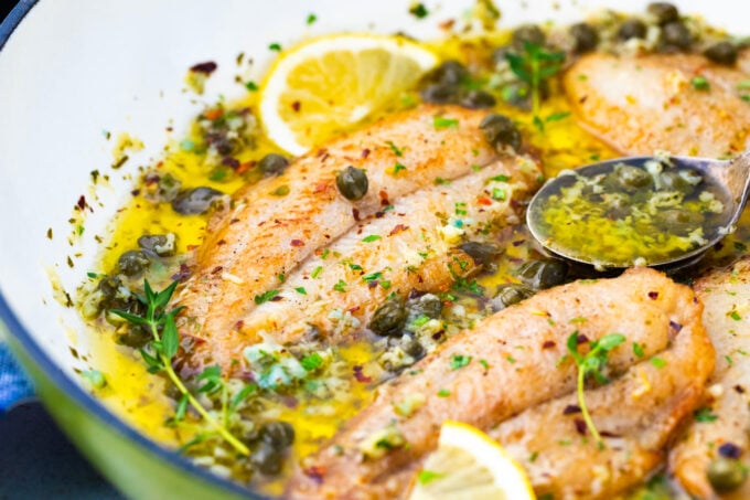 Lemon garlic butter swai fish in a pan.