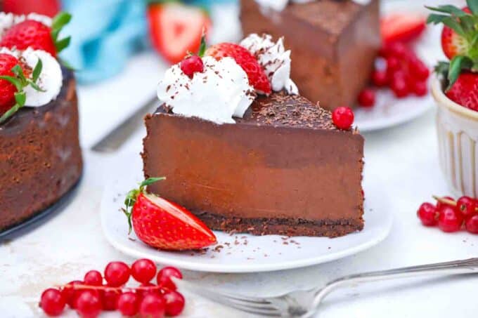 a slice of godiva chocolate cheesecake topped with chocolate ganache