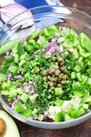 a bowl of chopped veggies and fresh herbs