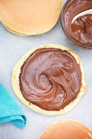 topping a pancake with nutella spread