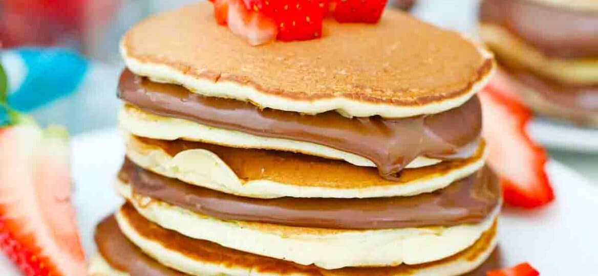 a stack of nutella pancakes topped with strawberries