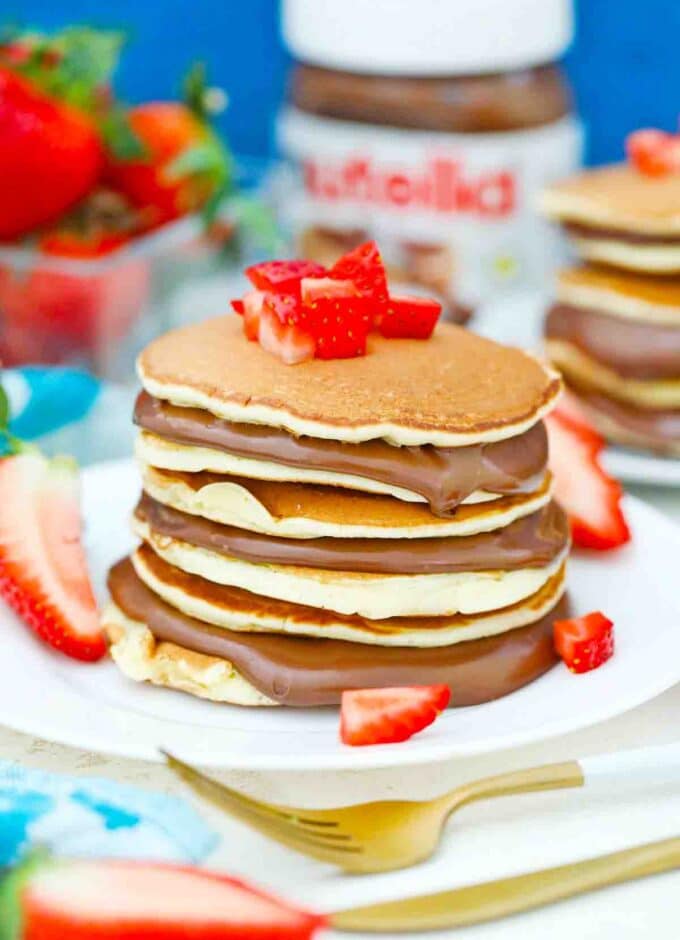 a stack of nutella pancakes topped with strawberries