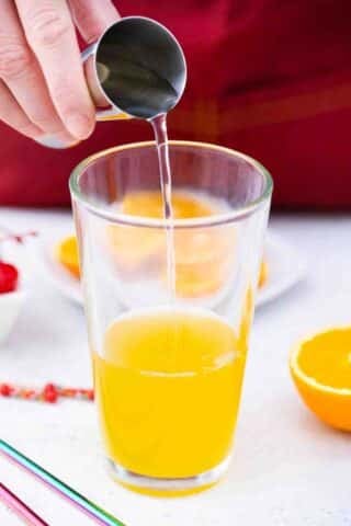 adding tequila to orange juice