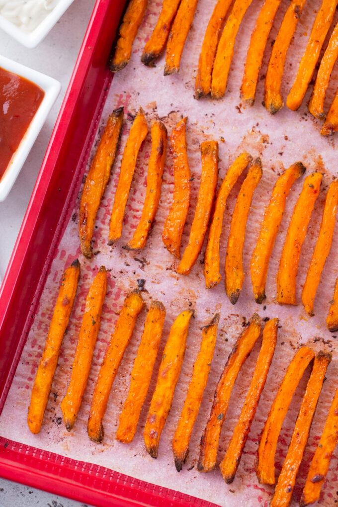 Crispy oven roasted sweet potato fries on a baking dish.