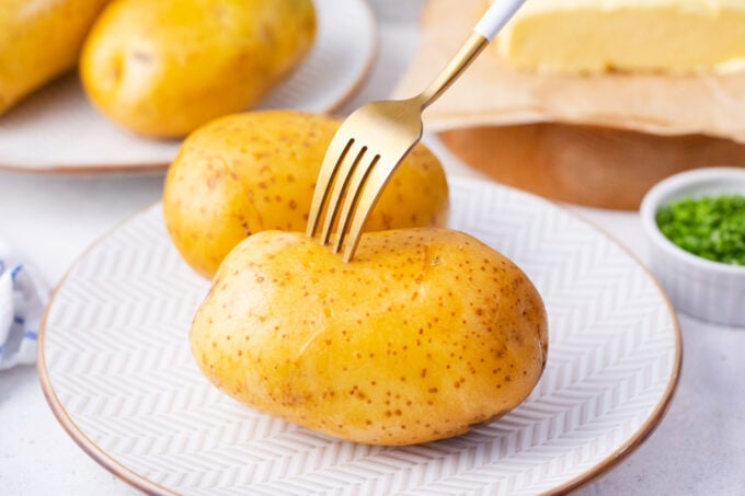 Poking a potato with a fork.