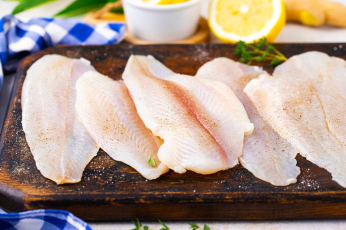Swai fish fillets on a cutting board.