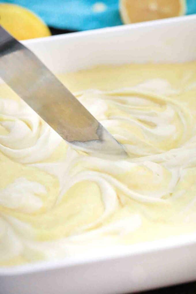 swirling cream cheese batter into lemon cake batter to make lemon earthquake cake