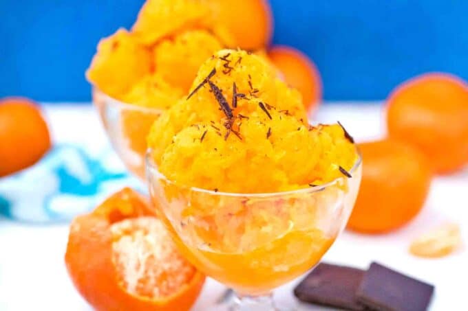 tangerine sorbet in ice cream cups with fresh tangerines in the background