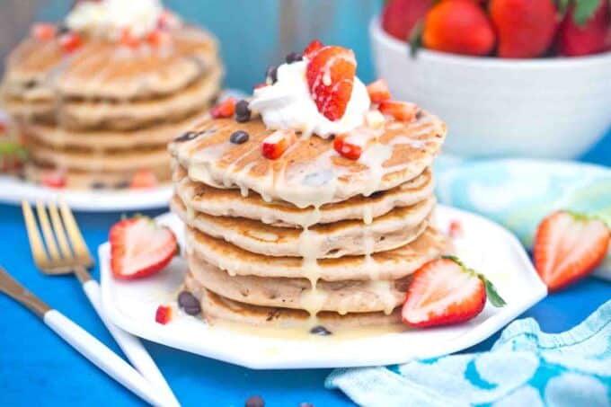 tres leches pancakes topped with berries and whipped cream