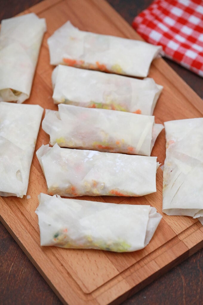 Panda Express chicken egg rolls arranged on a cutting board, before frying them.