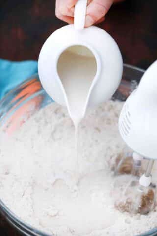 adding warm milk yeast mixture to flour