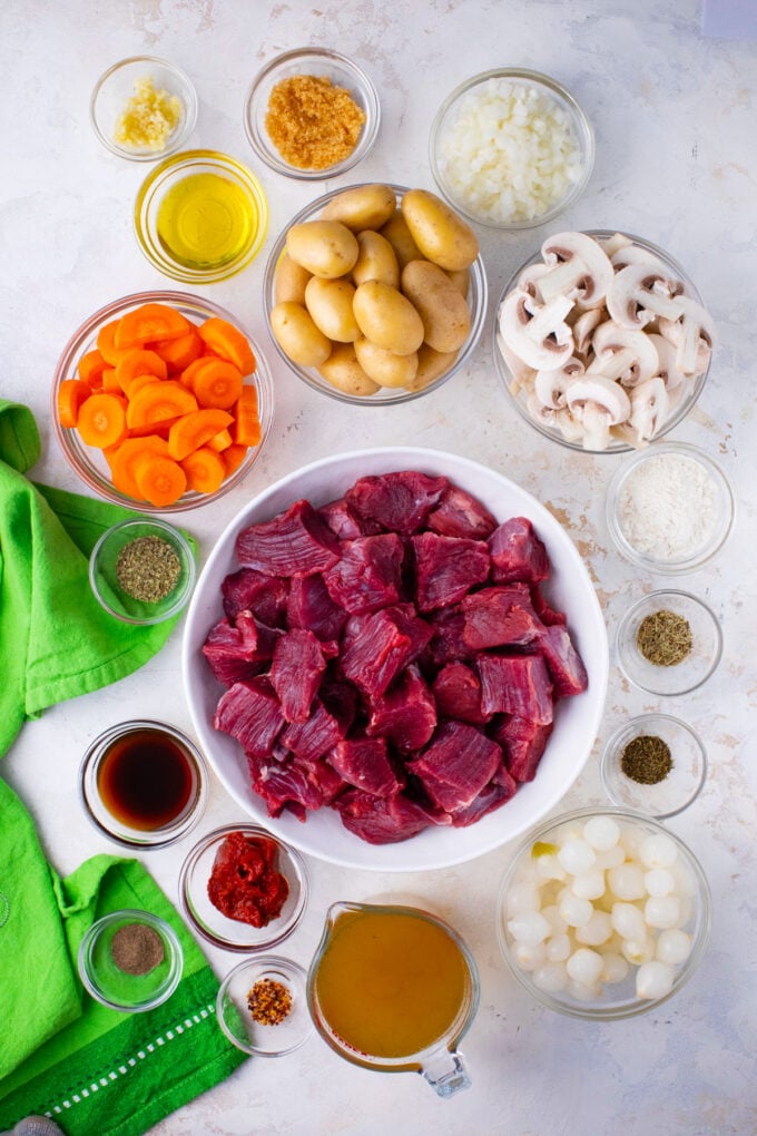 Overhead shot of Instant Pot beef stew ingredients in bowls on a table.
