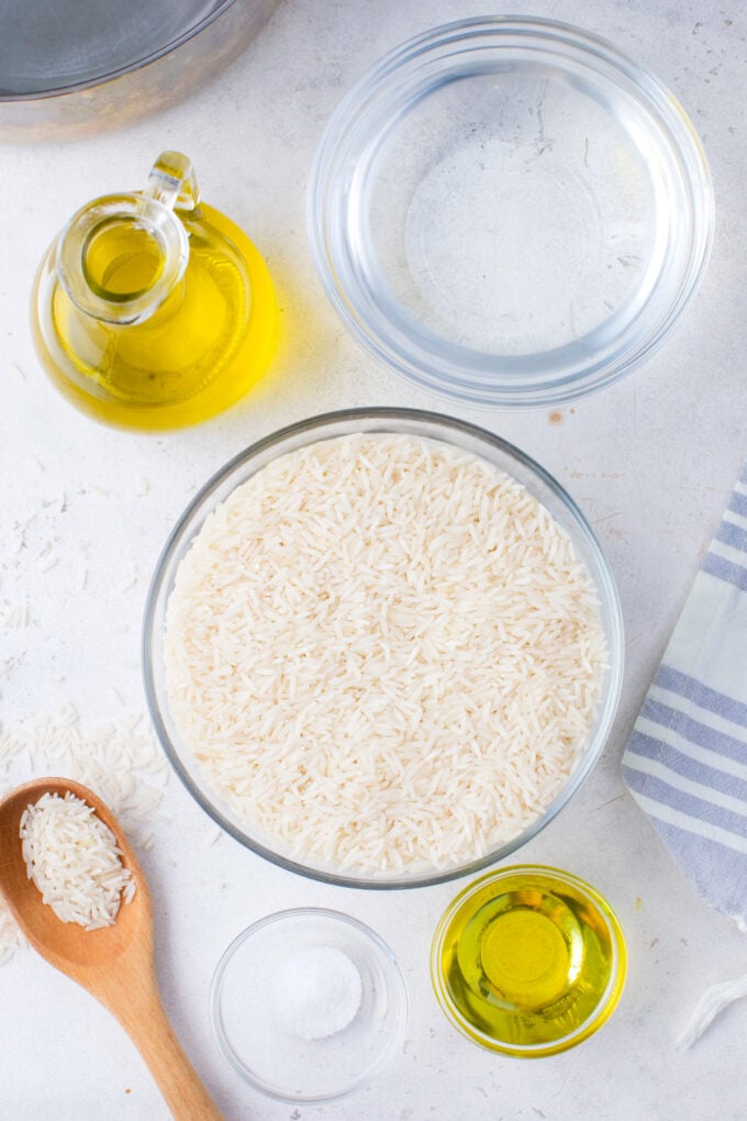 Overhead shot of rice in the Instant Pot ingredients in bowls on a white surface.