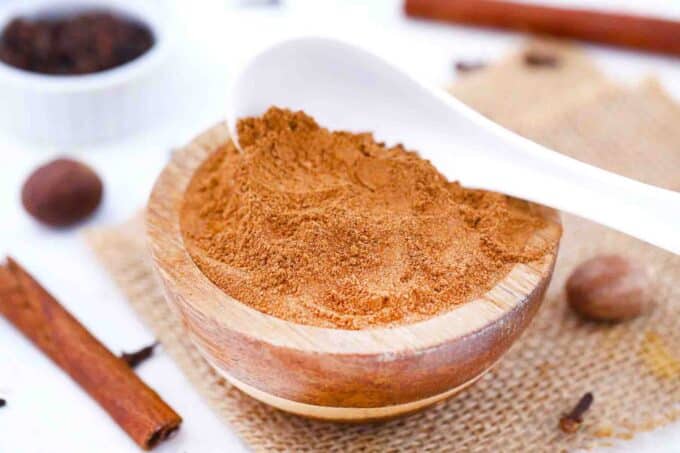 all spice substitute in a wooden bowl with a white spoon