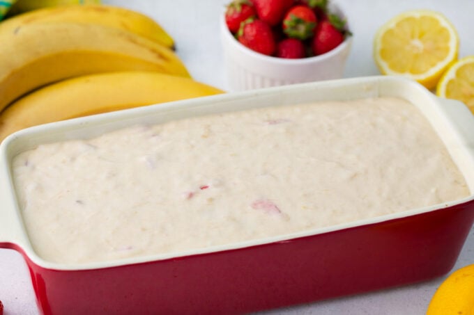 Loaf pan with strawberry banan bread batter.