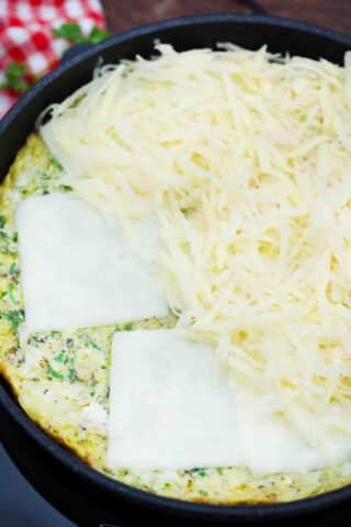 shredded potatoes egg mixture and cheese in a pan