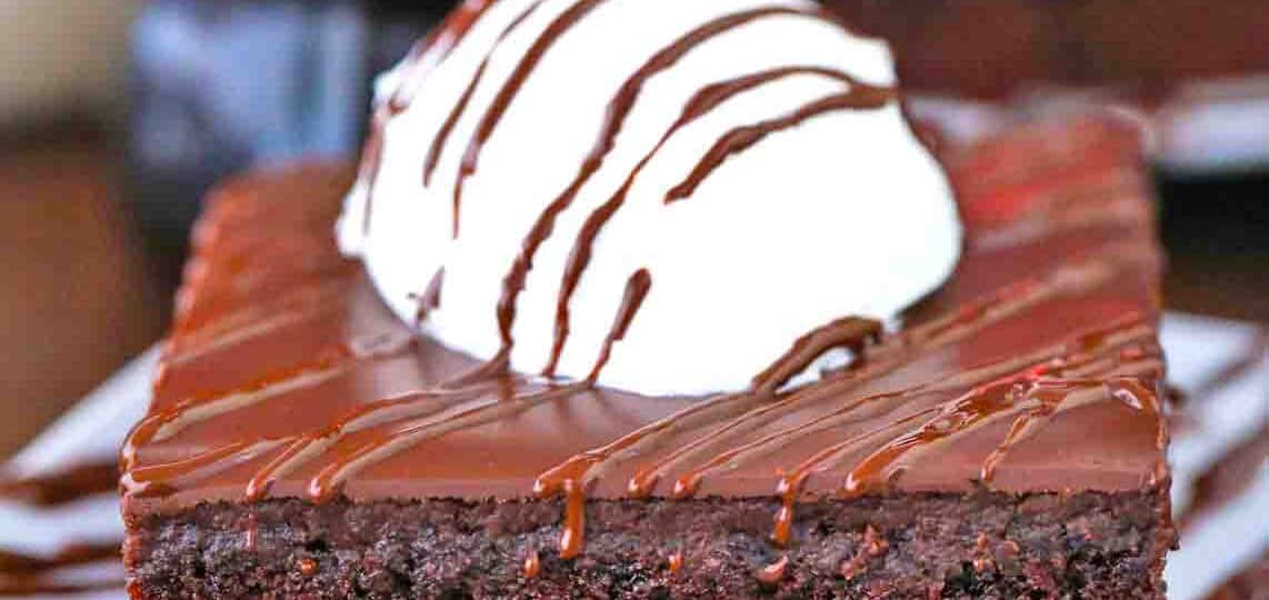 a slice of cracker barrel coca cola cake topped with ice cream