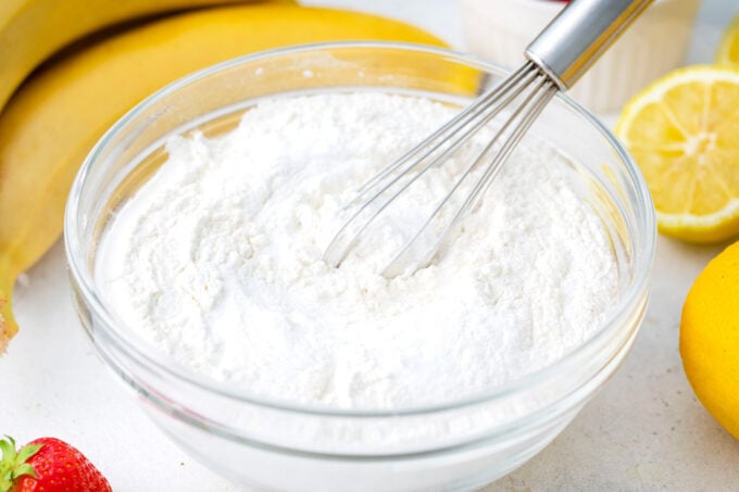 Whisking dry ingredients in a bowl to make strawberry banana bread.