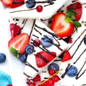 frozen yogurt bark topped with berries and chocolate drizzle