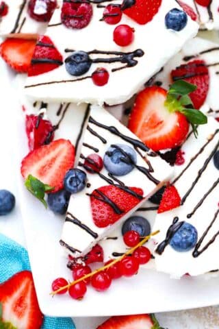 frozen yogurt bark topped with berries and chocolate drizzle