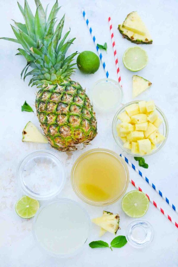 overhead shot of fresh pineapple and other ingredients needed to make pineapple mojito