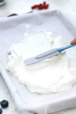 spreading greek yogurt on a baking pan