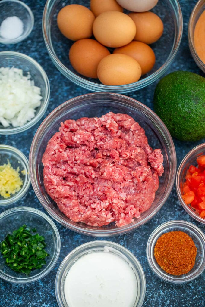 Overhead shot of Mexican taco burrito ingredients in bowls on a table.