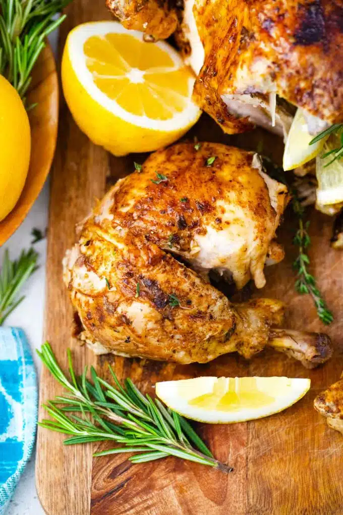 instant pot chicken pieces on a cutting board with lemon and rosemary