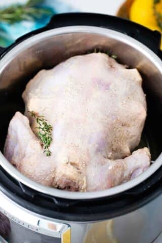 whole chicken coated in butter in the instant pot