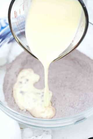 adding wet ingredients to dry ingredients to make pancakes