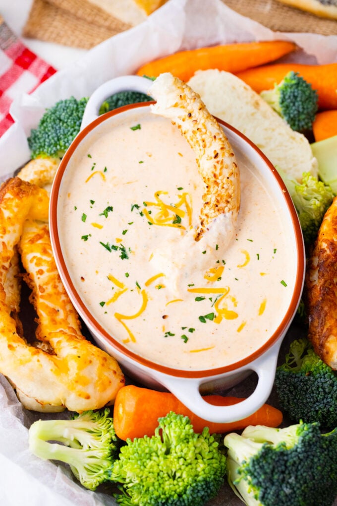 A platter of beer cheese dip and veggies.