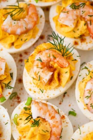 deviled eggs with old bay shrimp topped with green onions and dill