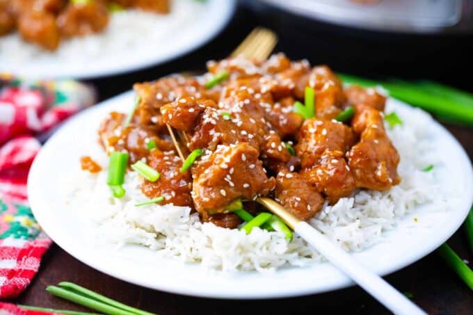 instant pot mongolian chicken served over rice with sesame seeds and green onions