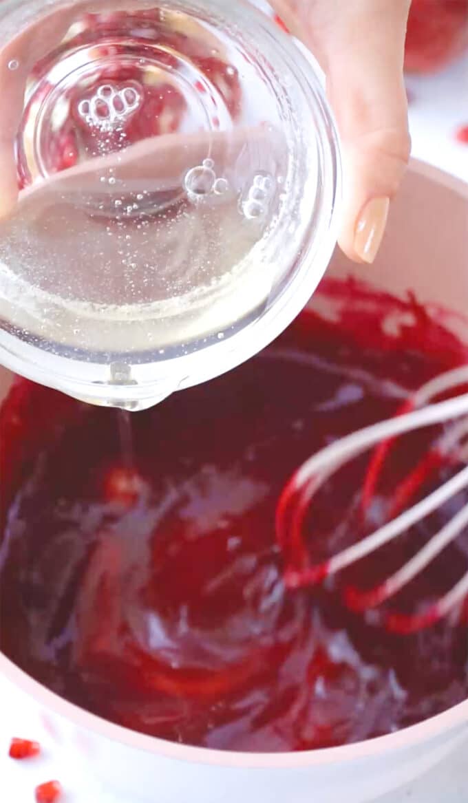 adding gelatin mixture to a saucepan with pomegranate sauce