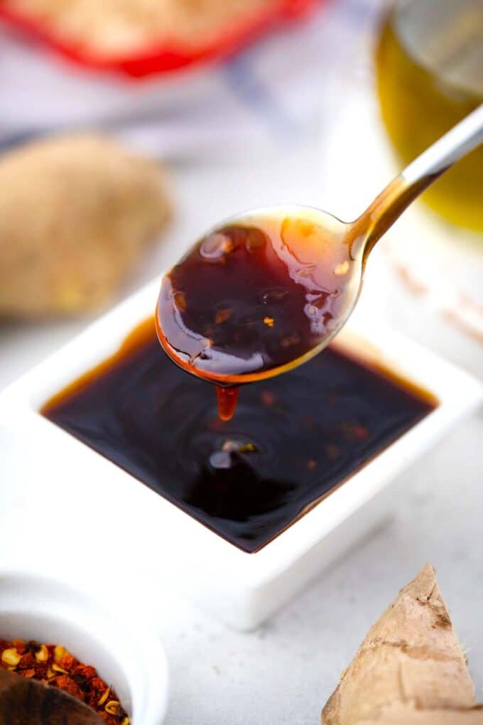 general tso sauce dripping of a spoon into a bowl