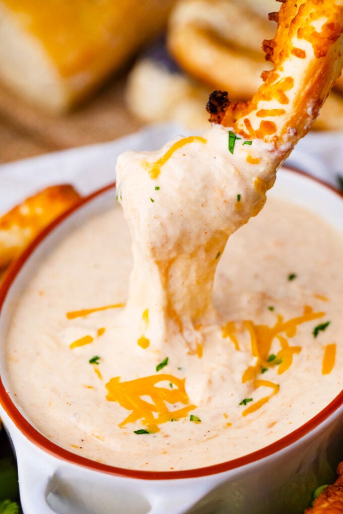 Dipping a pretzel into homemade beer cheese dip.