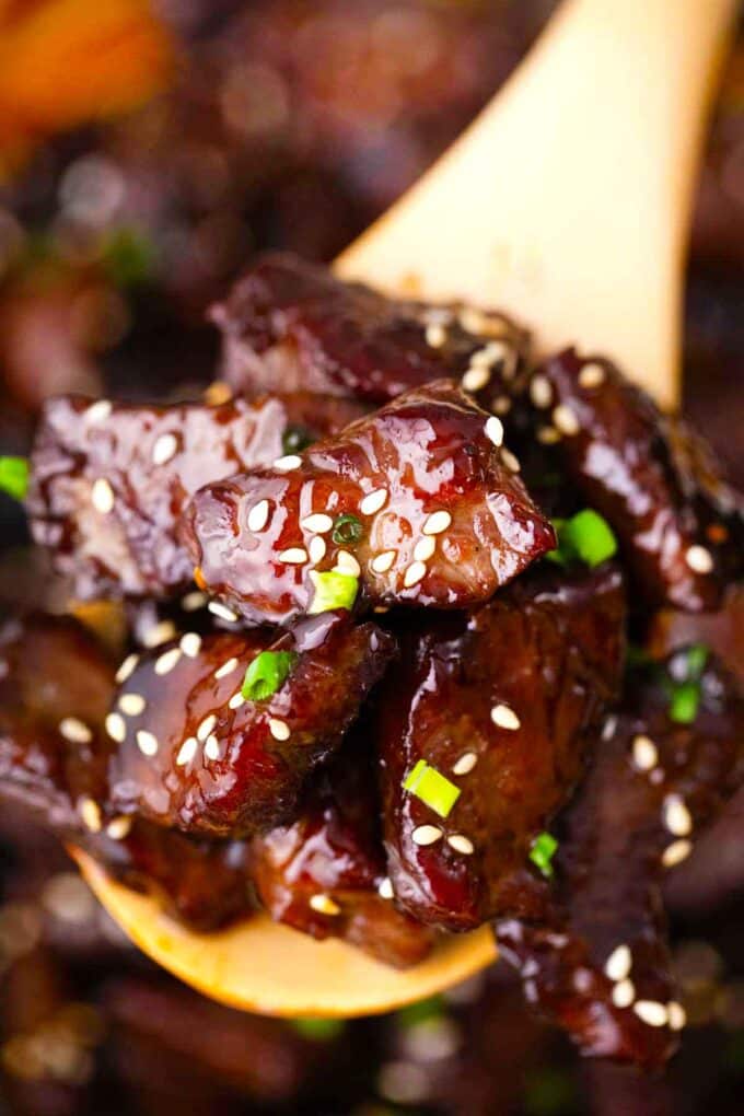 a wooden spoon with homemade sticky honey garlic beef