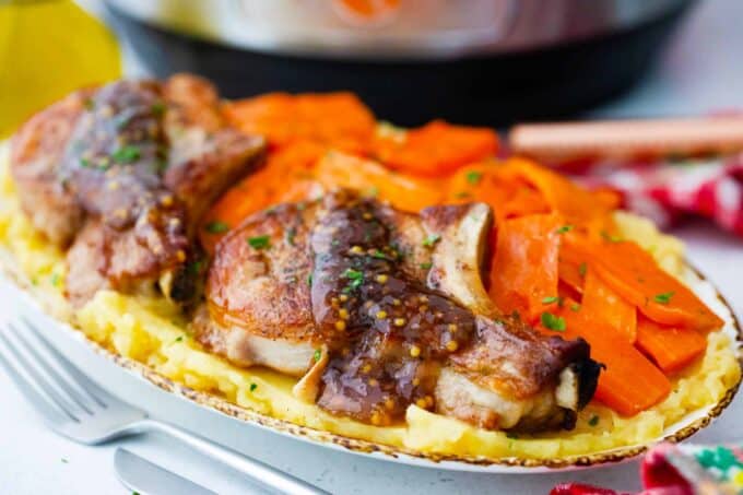 instant pot apple cider pork chops with carrots and mashed potatoes on a serving plate