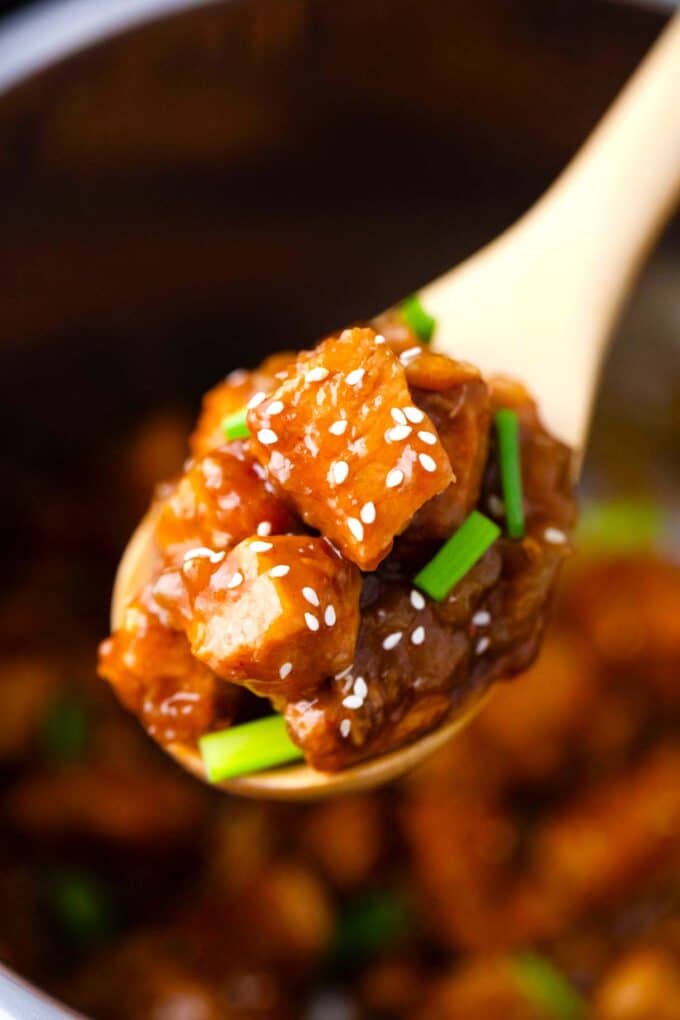 a spoonful of instant pot mongolian chicken with sesame seeds and green onions