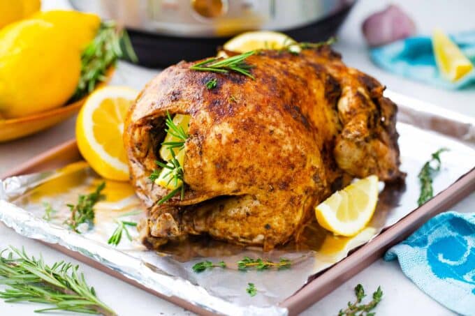 instant pot whole chicken on a baking tray next to an instant pot