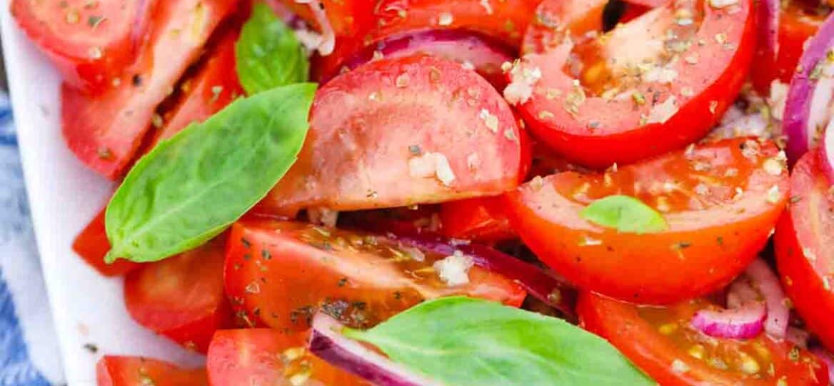 italian tomato onion salad garnished with fresh basil leaves