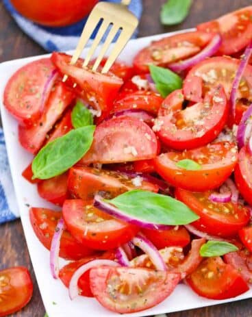 italian tomato onion salad garnished with fresh basil leaves