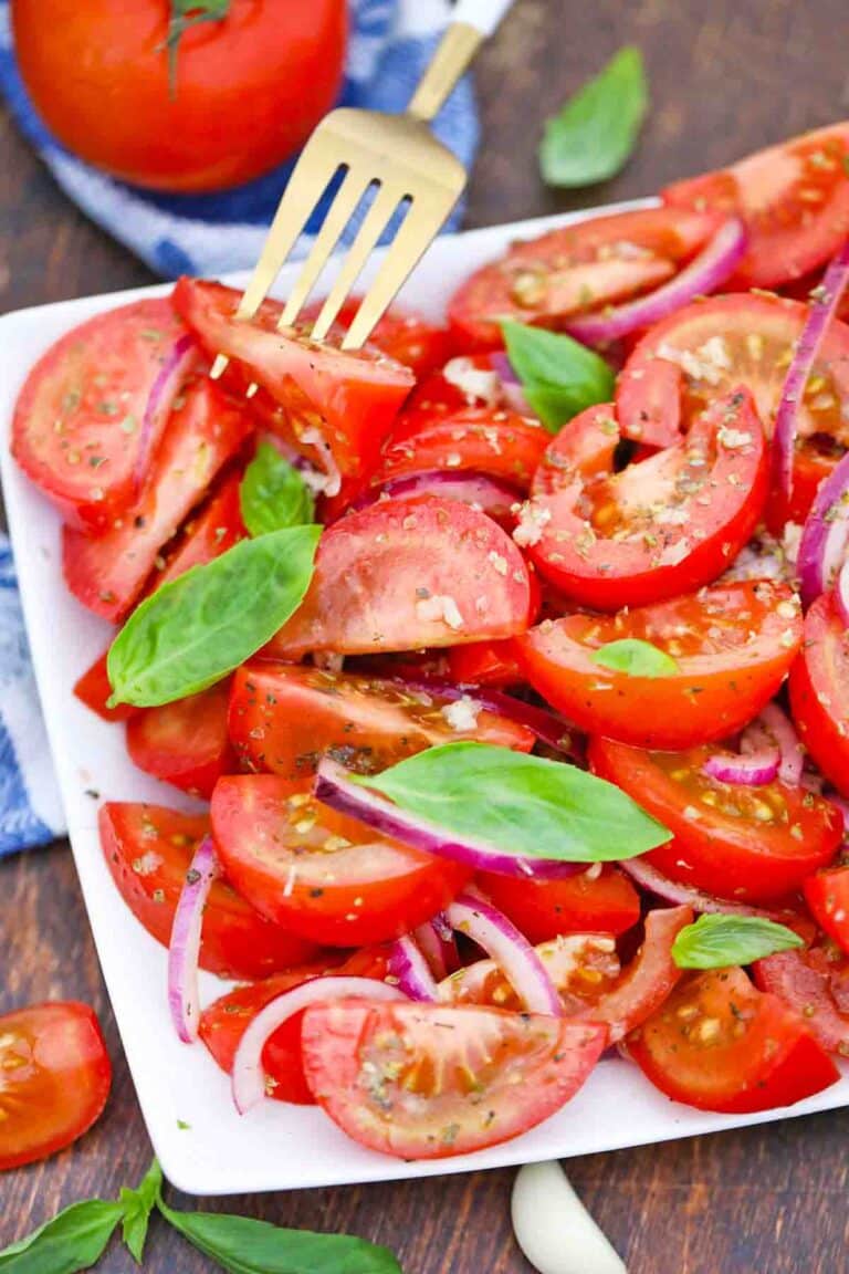 italian tomato onion salad garnished with fresh basil leaves